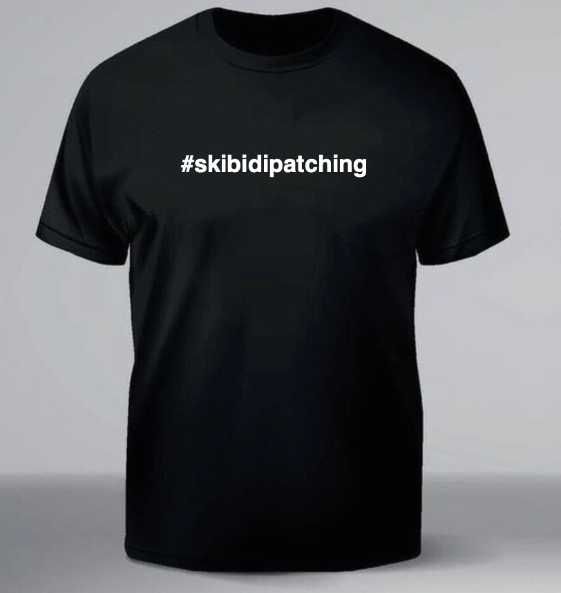Black t-shirt with '#skibidipatching' text on a gray background, #skibidipatching skibidipatching tecnici artificiali tecniciartificiali